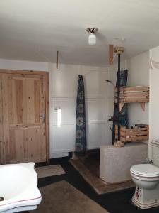 ein Badezimmer mit einem WC und einer Holztür in der Unterkunft Das! Boot auf dem Meer in Safaga 