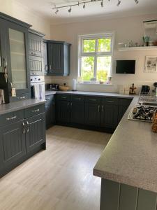 a kitchen with black cabinets and a counter top at Rooms in Hadleigh,Essex in Hadleigh