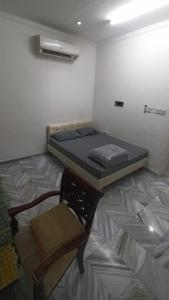 a room with a bed and a chair in it at Budget Muscat Room in Seeb