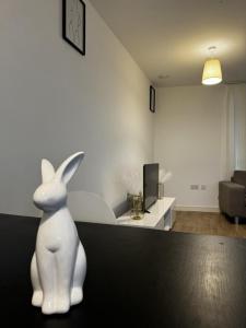 a white rabbit statue sitting on a table in a living room at Greenwich Glamorous 2-Bed Apartment in London
