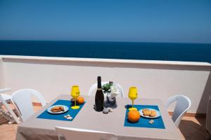 una mesa con comida y una botella de vino. en La terrazza del sole “ apartments “, en Marettimo