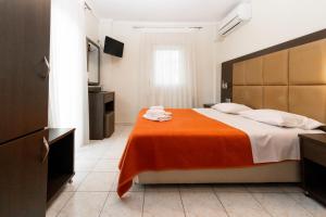 a bedroom with a large bed with an orange blanket at Hotel Avra in Perea