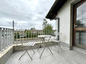 una mesa y 2 sillas sentadas en un balcón en LE BRASILIA - Terrasse & Parking, en Mont-de-Marsan