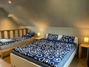 1 dormitorio con 2 camas con sábanas azules y blancas en Svītrainās mājas, en Pāvilosta