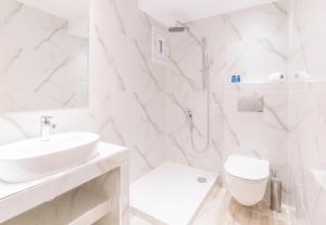 a white bathroom with a sink and a toilet at Hotel Avra in Perea