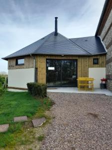 a house with a yellow table in front of it at Le Manège in Thiétreville +9 photos