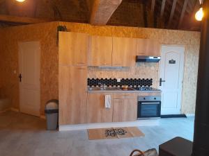 a kitchen with wooden cabinets and a stove top oven at Le Manège in Thiétreville