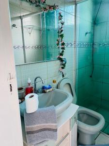 Baño azul con lavabo y aseo en Casa de dois quartos para 6 pessoas-Casa das Flores, en Ouro Preto