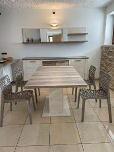 a kitchen with a wooden table and two chairs at Villetta sulle dolomiti in Pracorno di Rabbi