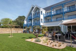 un edificio con una mesa y sillas en un patio en Best Western Plus Le Roof Vannes Bord de Mer, en Vannes