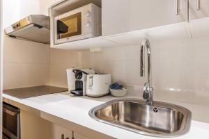 a kitchen with a sink and a microwave at Cosy apartment - Chatelet in Paris