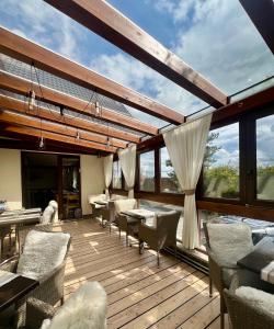 a large deck with chairs and tables and windows at Penzión Darinka in Poprad