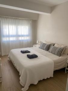 1 dormitorio blanco con 2 toallas en una cama grande en Apartamento centrico familiar en Valencia( Frente Estacion Ave ,Joaquin Sorolla), en Valencia