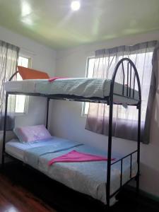 two bunk beds in a room with two windows at MAK Homstay Room in Kundasang