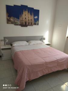 una camera da letto con un grande letto con una coperta rosa di LA SISTEMAZIONE BRILLANTINO GOLD a Rozzano