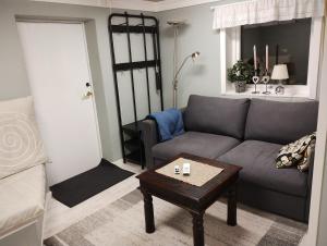 uma sala de estar com um sofá e uma mesa de centro em Koselig liten leilighet med hyggelig uteplass em Kragerø