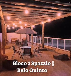 patio ze stołem, krzesłami i parasolem w obiekcie Brotas Suítes Belo Quinto & Spazzio Bloco 2 w mieście Brotas