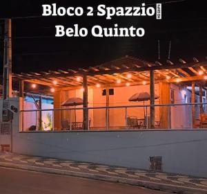 un bâtiment avec une terrasse dotée de tables et de parasols dans l'établissement Brotas Suítes Belo Quinto & Spazzio Bloco 2, à Brotas