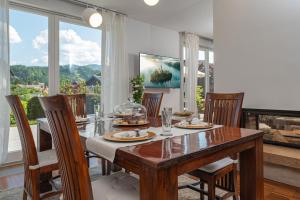 ein Esszimmer mit einem Tisch, Stühlen und Fenstern in der Unterkunft Luxury Apartment Nana in Bled