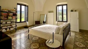 a bedroom with a bed and a mirror and windows at Masseria Celeste in Fasano