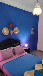a blue bedroom with a bed and a blue wall at j appartement in Essaouira