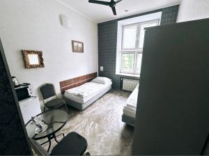 Habitación pequeña con cama, mesa y ventana en Pałac Dąbrowa en Dąbrowa Górnicza