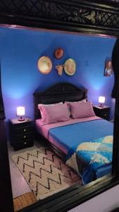 a bedroom with a bed with a blue wall at j appartement in Essaouira