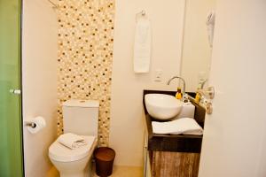 a bathroom with a sink and a toilet at Pousada Bora Bora in Bombinhas