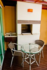 einen Glastisch, 2 Stühle und ein Waschbecken in der Unterkunft Pousada Bora Bora in Bombinhas