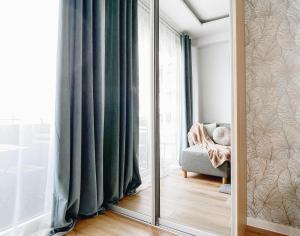 a mirror in a room with a chair and a window at Luxury Residence Gdansk in Gdańsk
