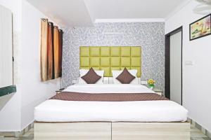ein Schlafzimmer mit einem großen Bett mit einem gelben Kopfteil in der Unterkunft The Rose Manor By Iconic Delhi International Airport in Neu-Delhi