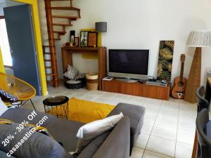 ein Wohnzimmer mit einem Sofa und einem Flachbild-TV in der Unterkunft Casa Sestina - Logement indépendant dans belle propriété avec piscine in Canohès