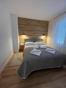 sypialnia z dużym łóżkiem z drewnianym zagłówkiem w obiekcie Apartman TeNeN w mieście Knin