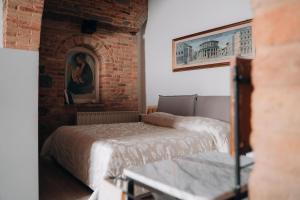 1 dormitorio con 2 camas y pared de ladrillo en Casa di Clara in Piazza, ideale per smartworking, en Amandola