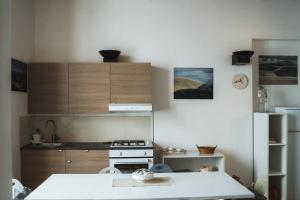 cocina con fogones y encimera blanca en Casa di Clara in Piazza, ideale per smartworking, en Amandola