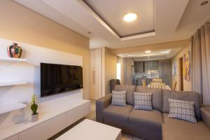 Kgaba Villas في Ramotswa: غرفة معيشة مع أريكة وتلفزيون بشاشة مسطحة
