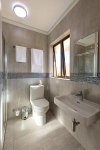 Kgaba Villas في Ramotswa: حمام مع مرحاض ومغسلة ومرآة
