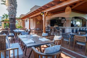 um restaurante com mesas e cadeiras num pátio em Atrium Palace Thalasso Spa Resort And Villas em Kalathos