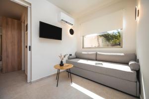 a living room with a couch and a table at Palm Tree Beach Suites, by ZanteWize in Alykes