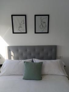 una camera da letto con tre immagini appese al muro sopra un letto di El Merendero a Utrera