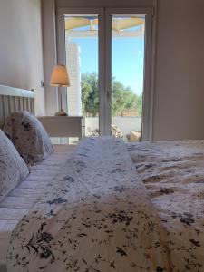 a bedroom with a large bed with a large window at The Saint George in Mastichari
