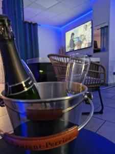 een fles wijn in een emmer met een glas bij Blue Lagoon Spas Montauban in Montauban
