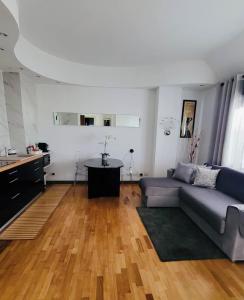 uma sala de estar com um sofá e uma mesa em San Siro Terrace Attic Apartment Milano em Milão