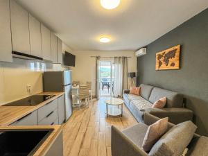 a kitchen and a living room with a couch and a table at Apartments Habek 2 in Vrboska