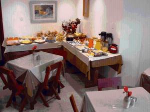 un comedor con una mesa con platos de comida en Pousada dos Bandeirantes, en Ouro Preto