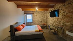 una camera con letto e muro di mattoni di B&B Locanda Montefabbri a Monte Fabbri