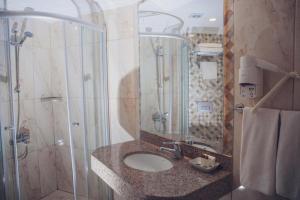 ein Bad mit einem Waschbecken und einer Dusche in der Unterkunft L'ancora Beach Hotel in Kemer