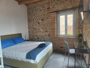 1 dormitorio con cama y pared de ladrillo en B&B Locanda Montefabbri, en Monte Fabbri