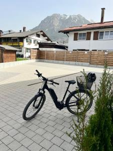 una bicicletta parcheggiata su un marciapiede in un cortile di Ferienwohnungen Müggelberge a Oberstdorf