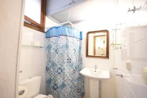 y baño con lavabo, aseo y espejo. en Masì House en Rodas